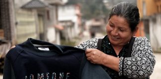 A woman holding a sustainabily made jumper